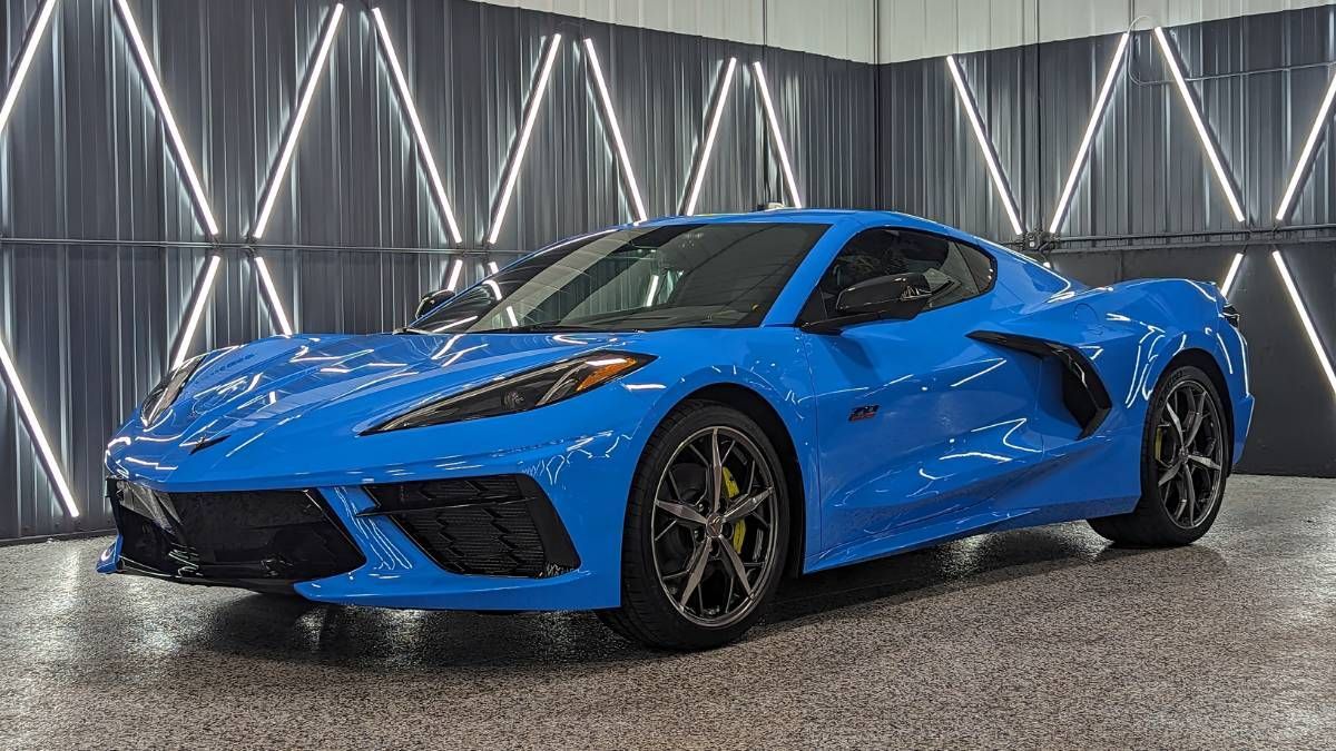 A blue sports car is parked in a garage.