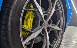 A close up of a car wheel with a yellow brake caliper.