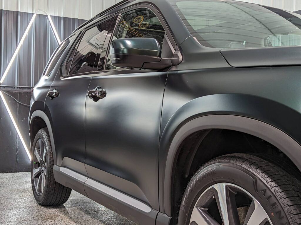 A black car is parked in a garage.