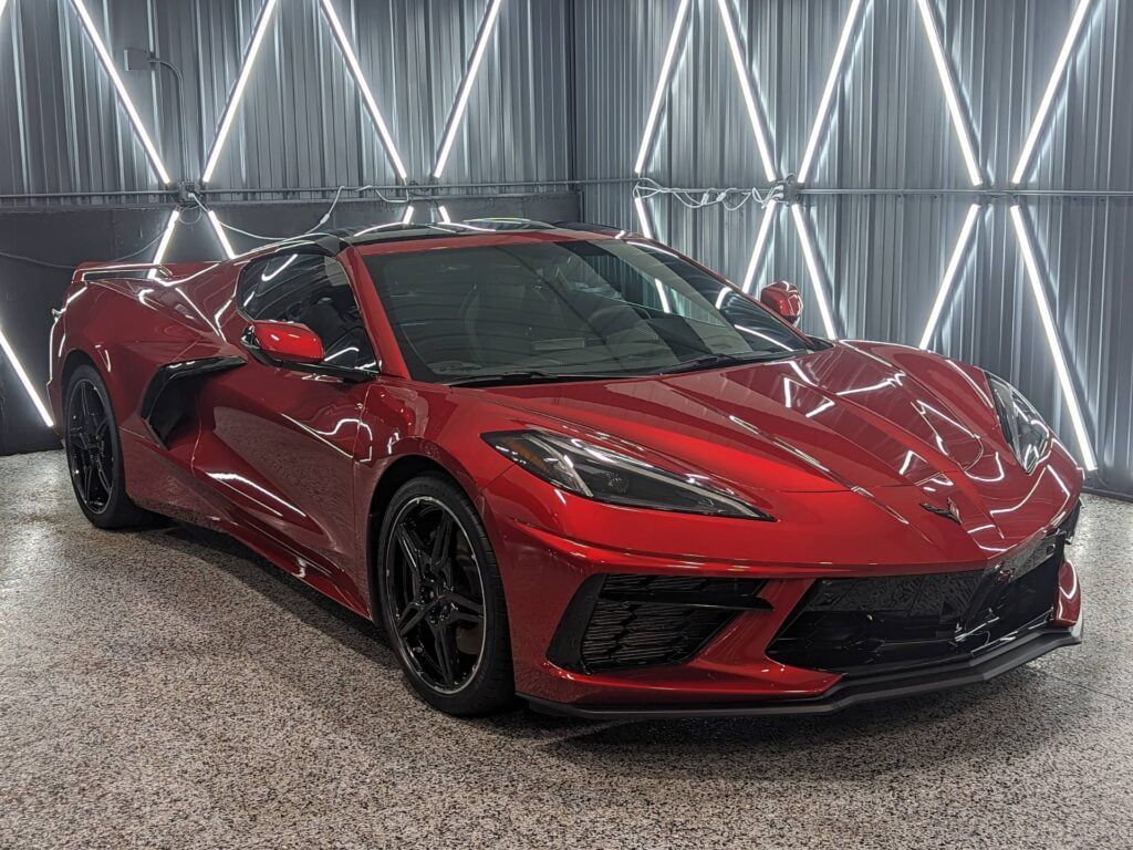 A red sports car is parked in a garage.