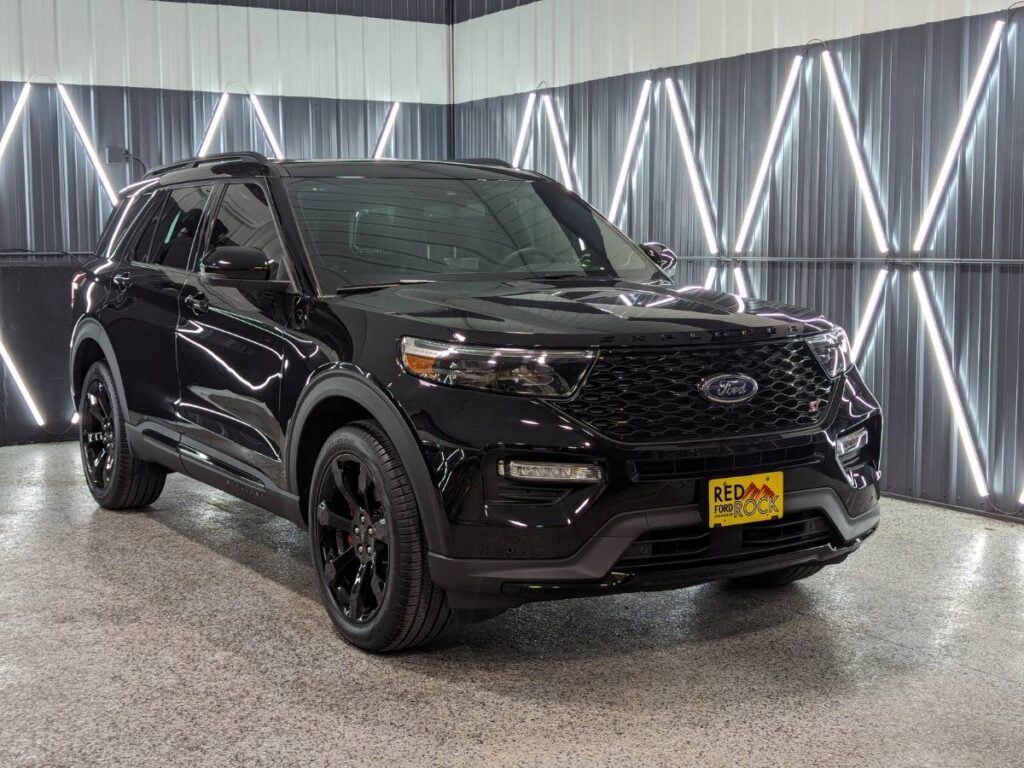 A black ford explorer is parked in a garage.