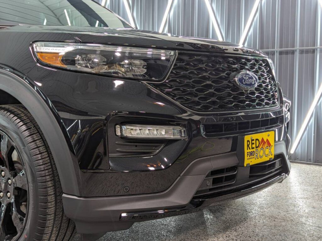 A black ford explorer is parked in a garage.