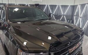 A black gmc truck is parked in a garage.