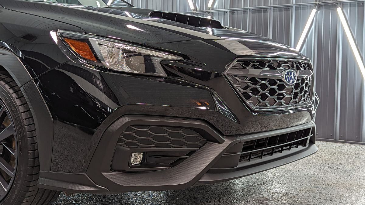 A black subaru wrx sti is parked in a garage.