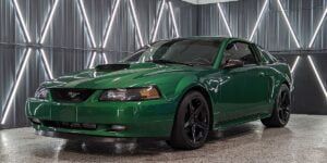 A green mustang is parked in a garage.