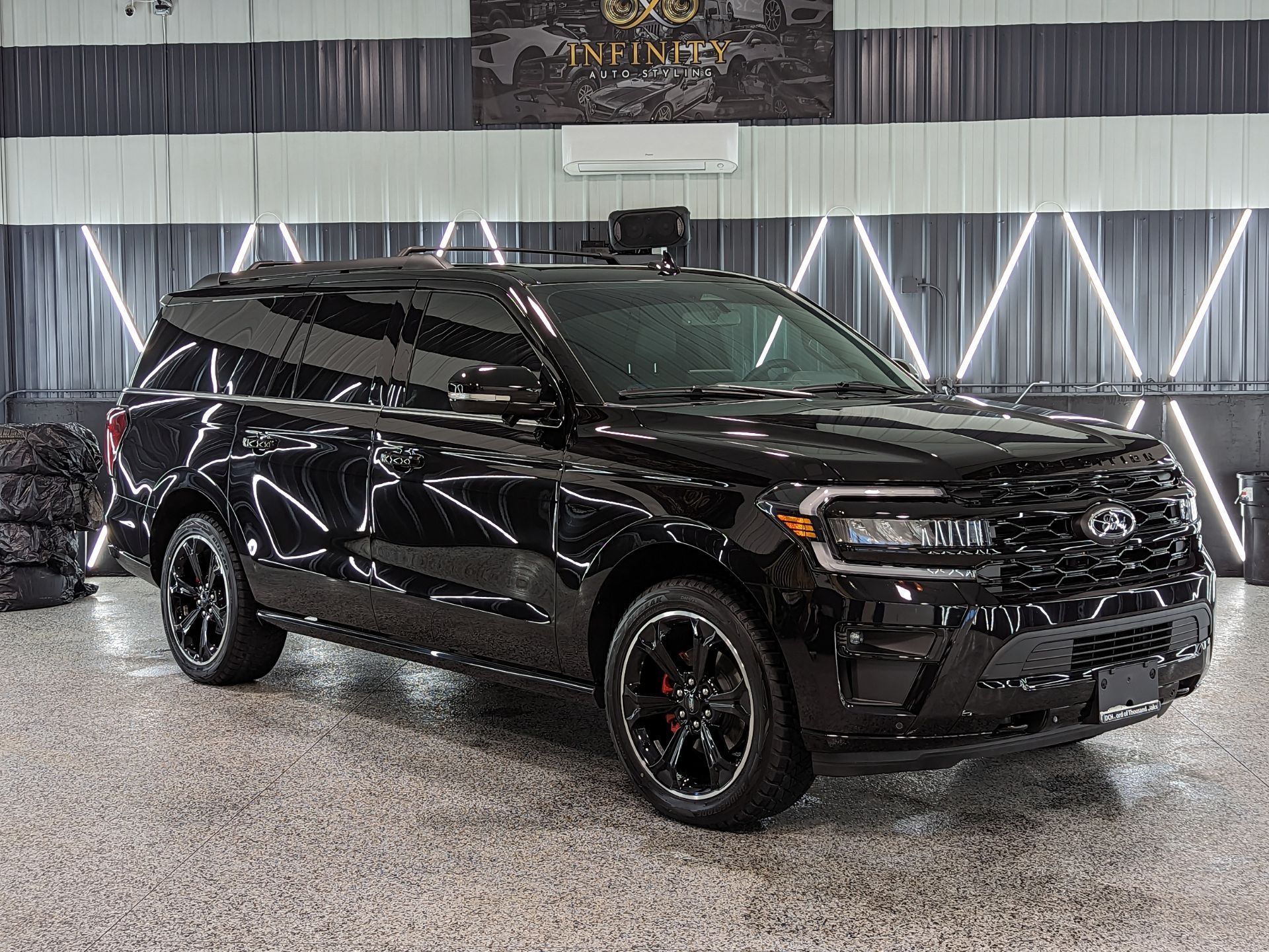 A black ford expedition is parked in a garage.