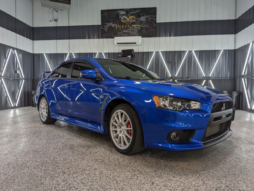 A blue mitsubishi lancer evo is parked in a garage.