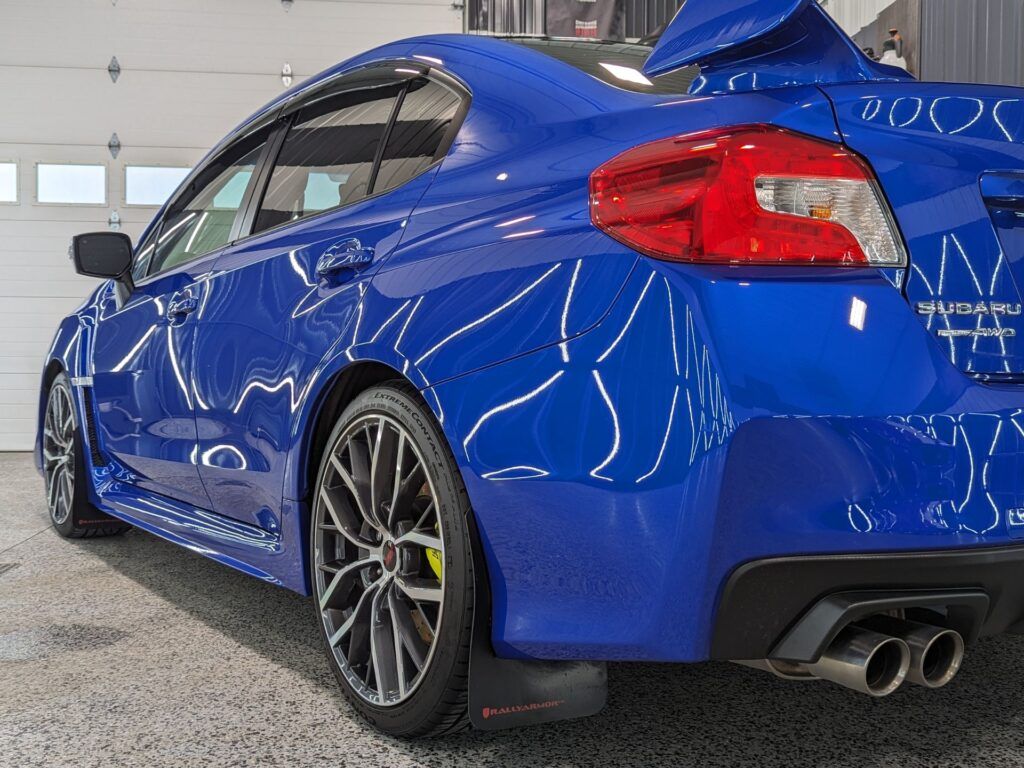 A blue subaru wrx sti is parked in a garage.