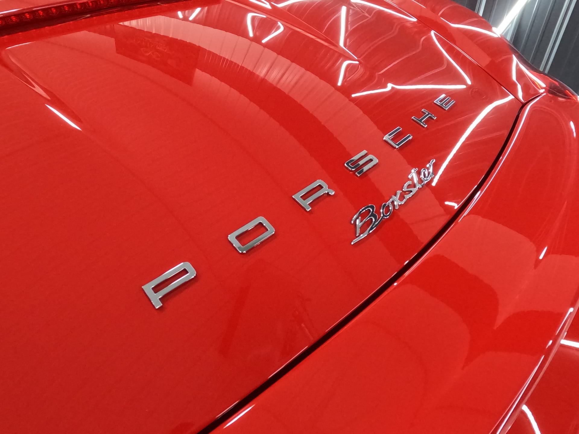 The word porsche is on the back of a red car