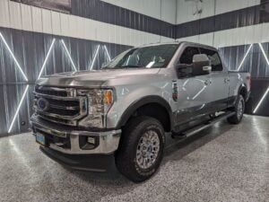 A silver ford f250 pickup truck is parked in a garage.