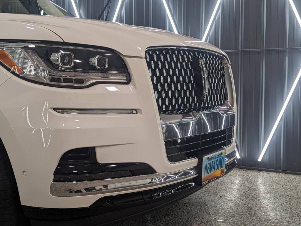 A white lincoln aviator is parked in a garage.