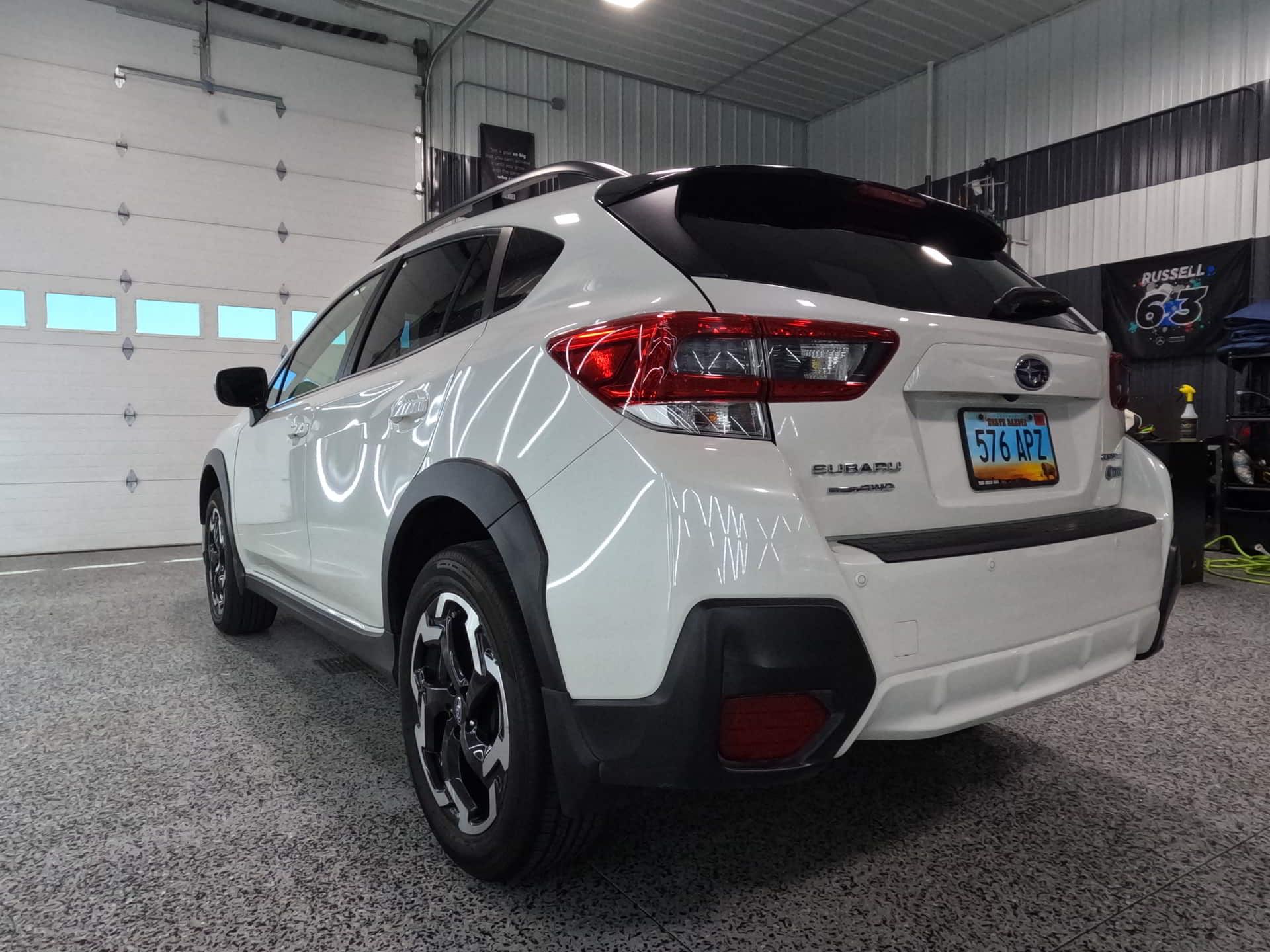 A white suv is parked in a garage next to a garage door.