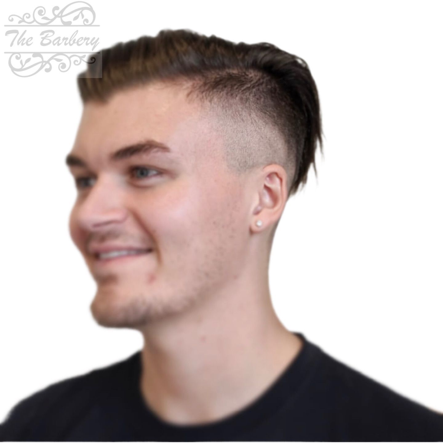 Man with a high skin fade haircut smiling. He is wearing a black shirt.