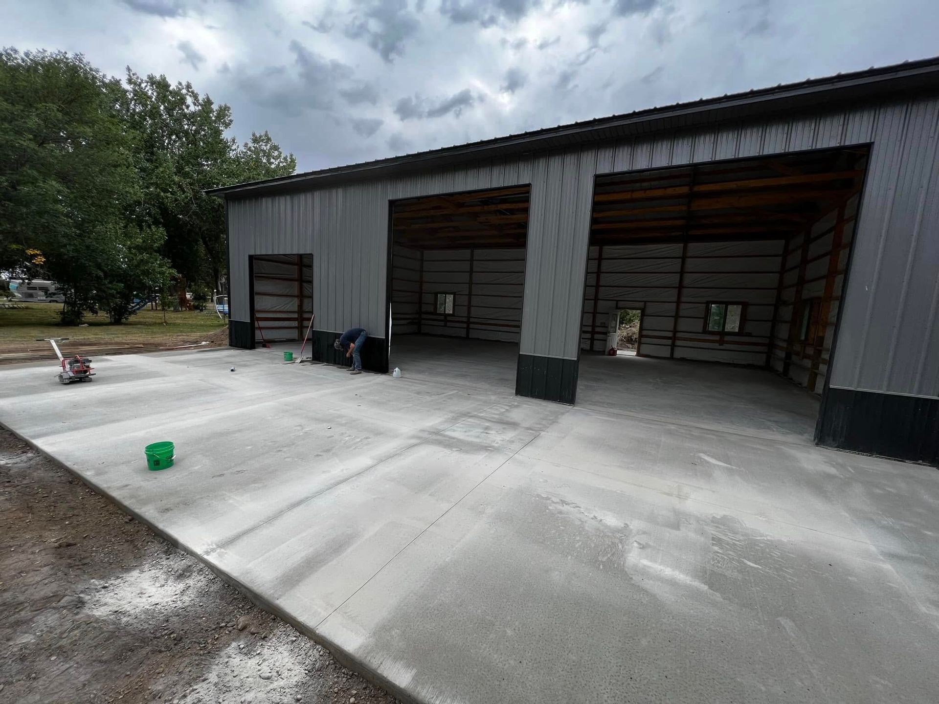 Metal building with three bays and freshly poured concrete floor.