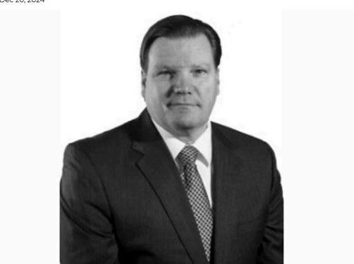 Man in suit, looking at the camera. Black and white portrait.
