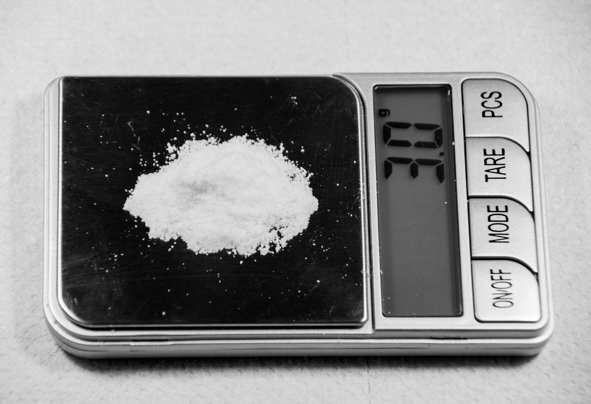 White powder on a digital scale displays 3.0E.