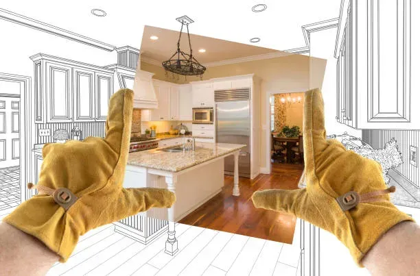 Hands in work gloves framing a kitchen remodel sketch, with a photograph of the finished space.