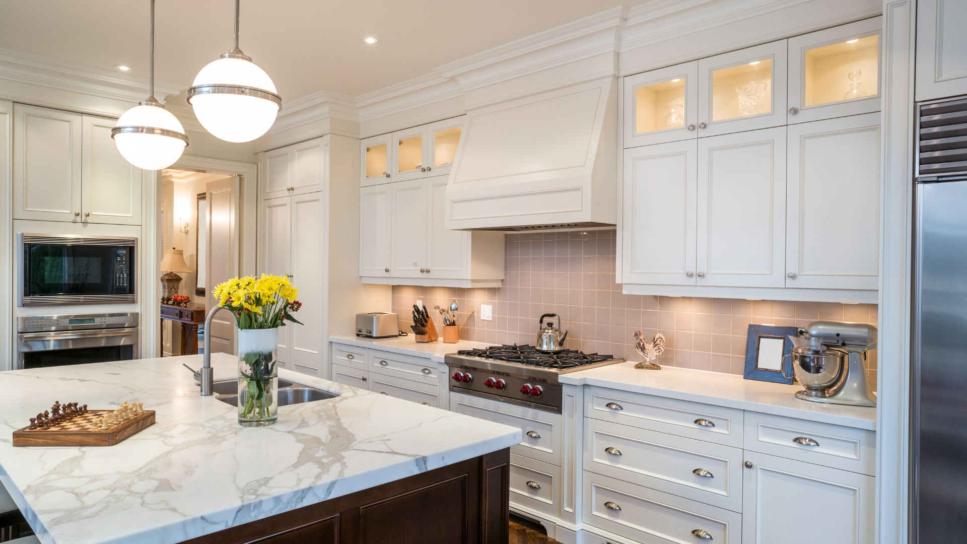 Kitchen with dark cabinets, a white island, and hardwood floors.