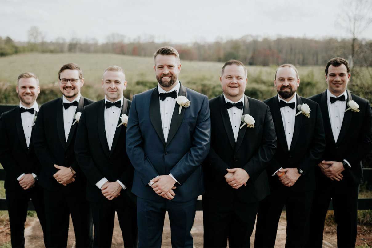 The groom and his groomsmen are posing for a picture together.