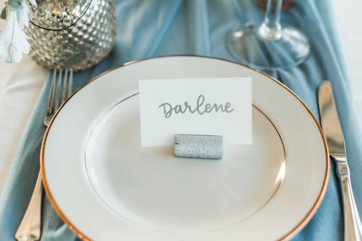 A white plate with a place card on it on a table.