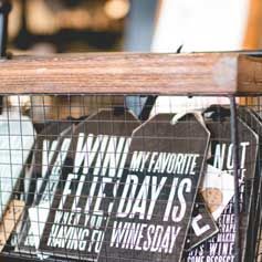 A basket filled with signs that say `` wine my favorite flea day is when you having fun winesday ''.