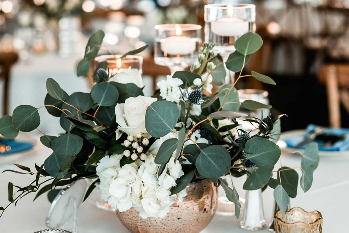 A vase filled with flowers and candles on a table.