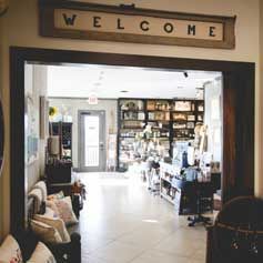 A welcome sign hangs above a doorway in a living room.