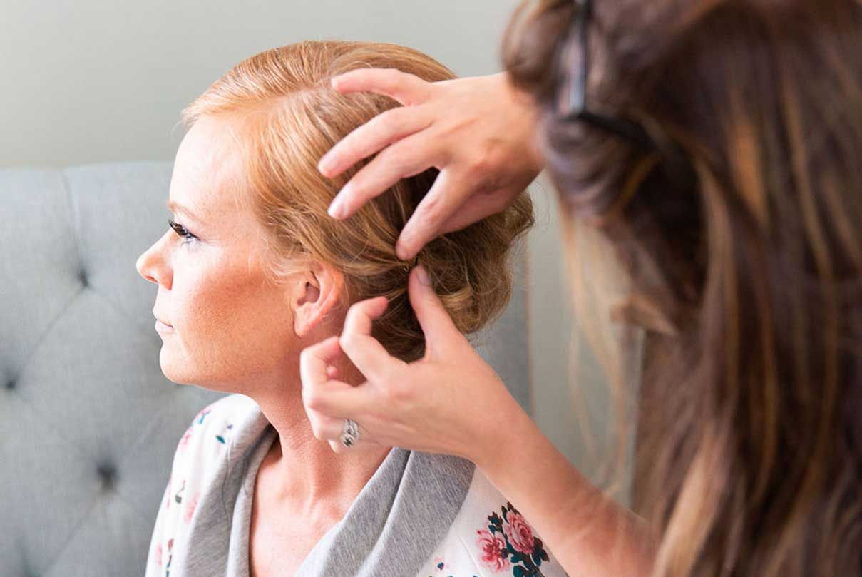 A woman is getting her hair done by a hairdresser.