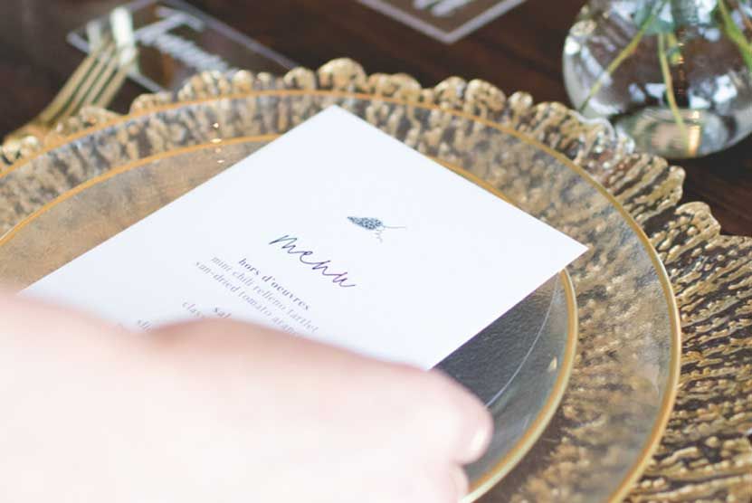 A person is putting a menu on a plate on a table.