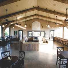 A large room with tables and chairs and a vaulted ceiling.