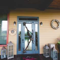 The front door of a house with lanterns and a wreath on it.