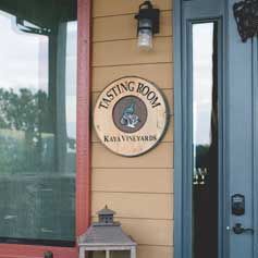 A sign on the side of a building that says `` tasting room ''.