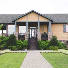 A large house with a brick walkway leading to the front door.