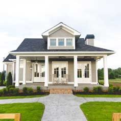 A large house with a porch and a walkway leading to it.