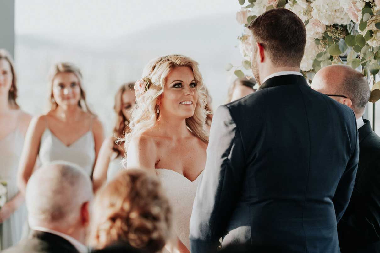 A bride and groom are holding hands during their wedding ceremony.
