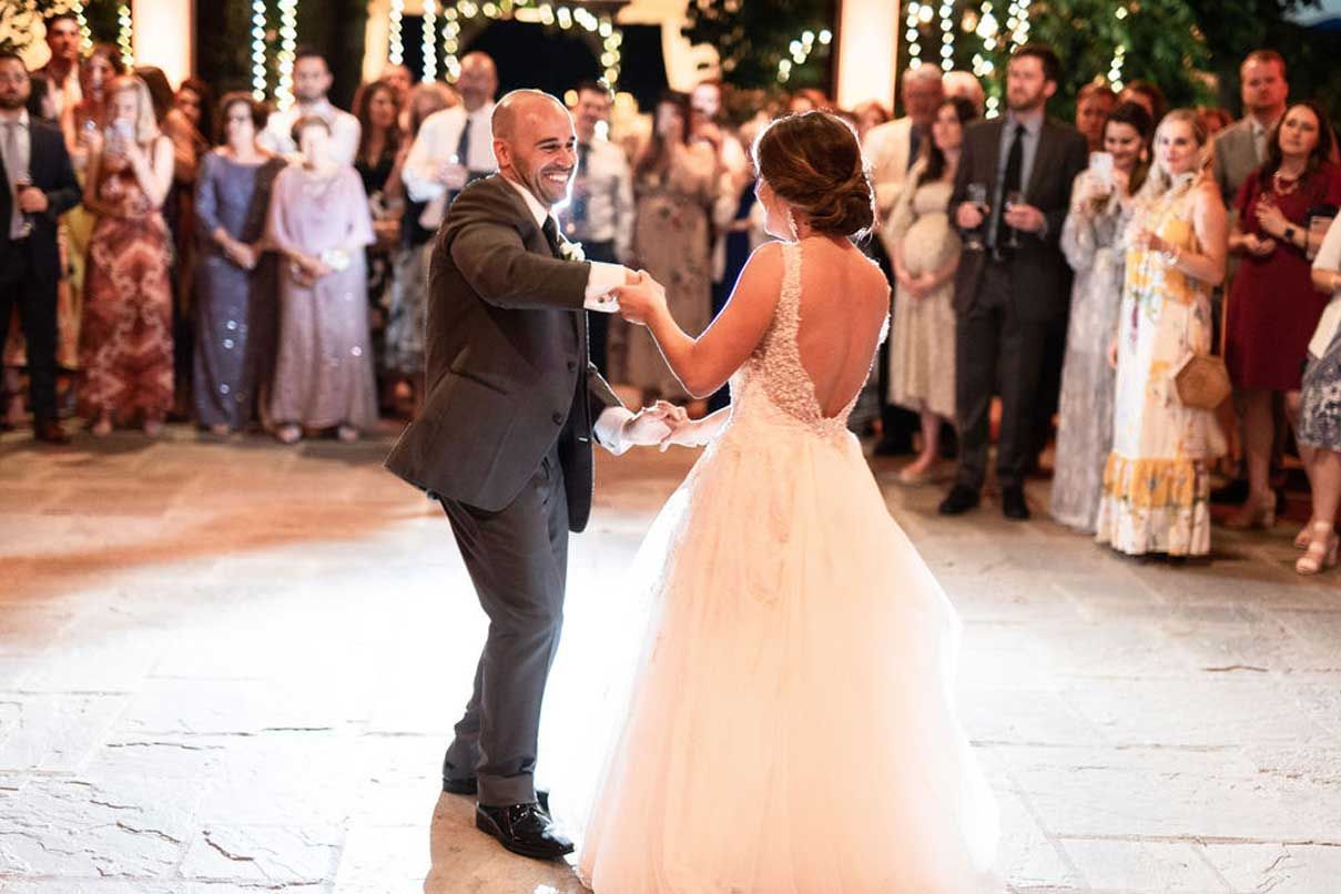 A bride and groom are dancing their first dance at their wedding reception.