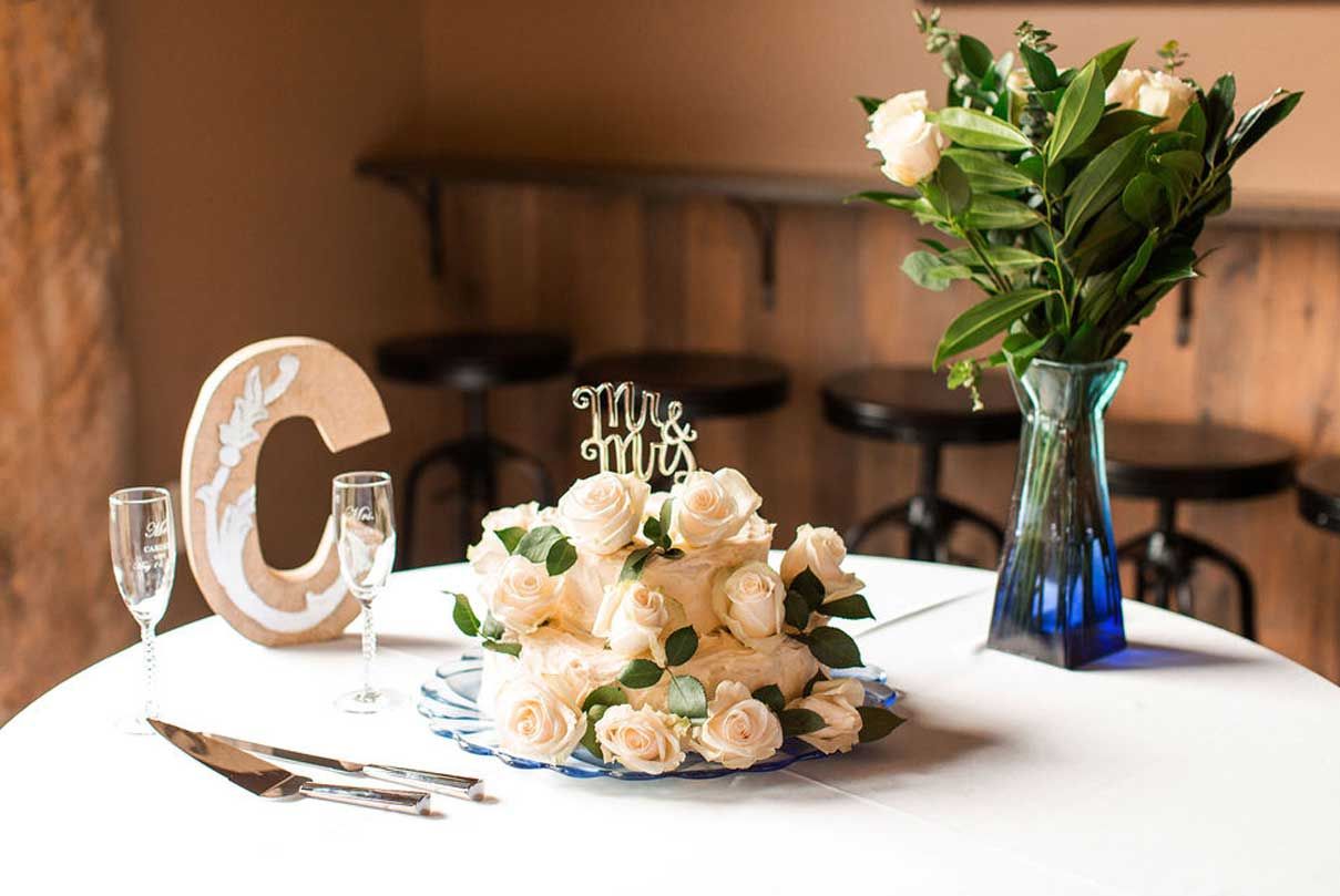 A table with a vase of flowers and a cake topper on it.