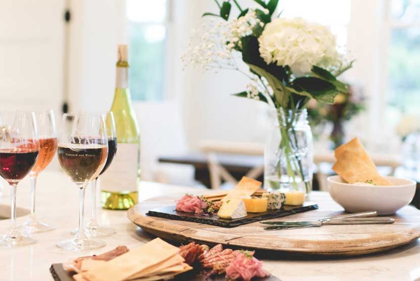 A table topped with a variety of food and wine glasses.