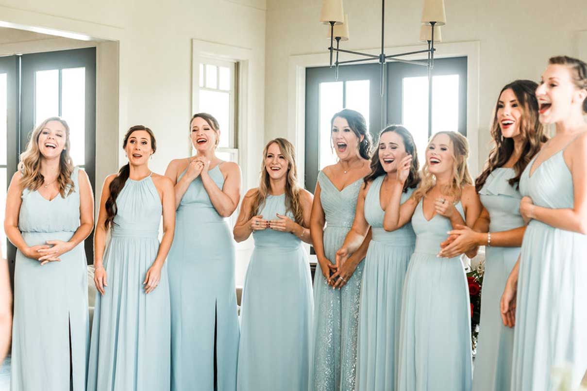 A group of bridesmaids are standing next to each other in a room.