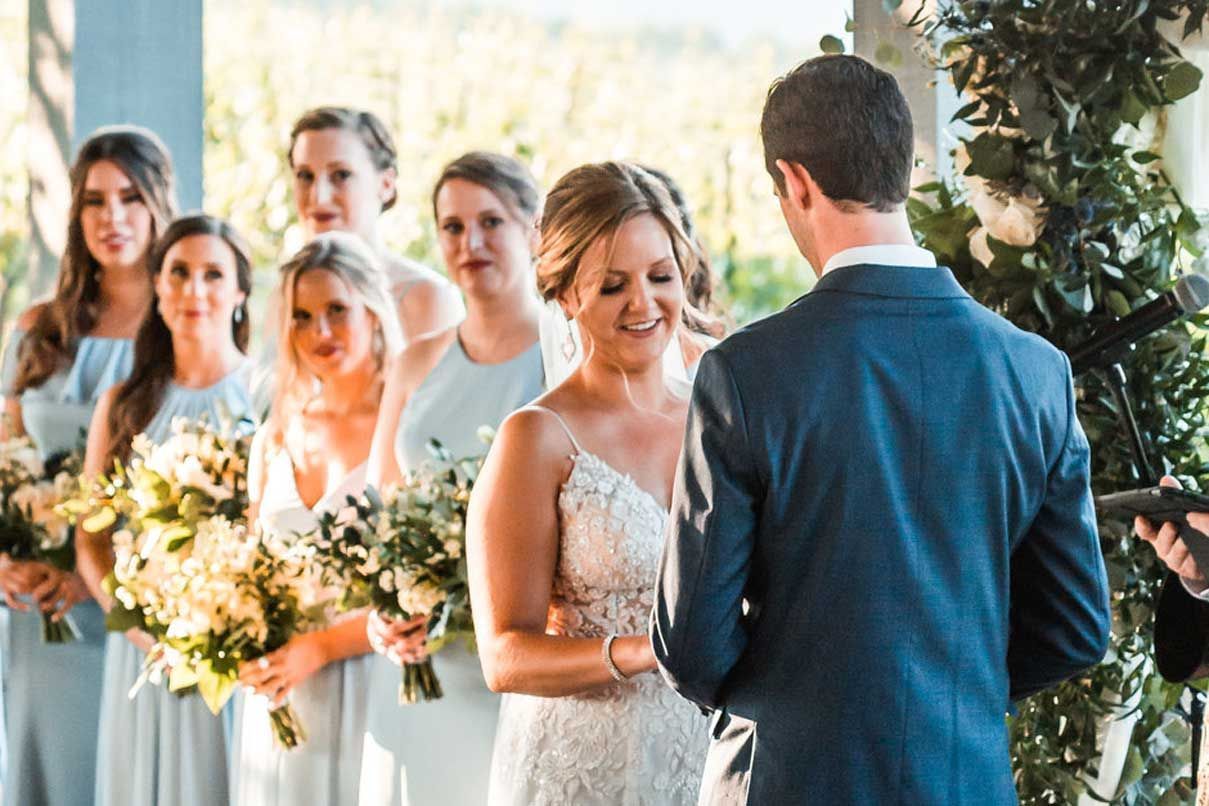 A bride and groom are getting married in front of their wedding party.