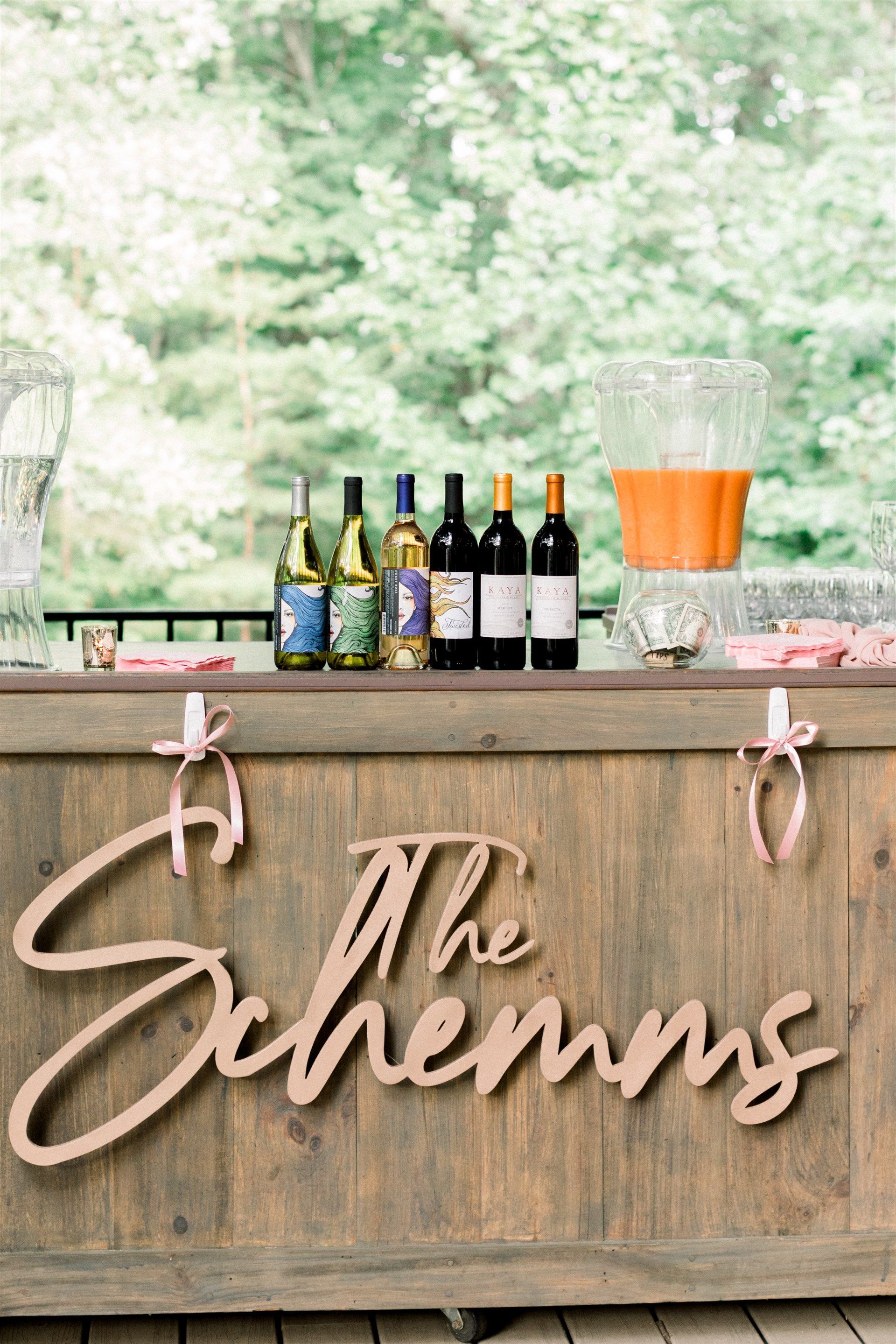 A wooden bar with bottles of wine and drinks on it.