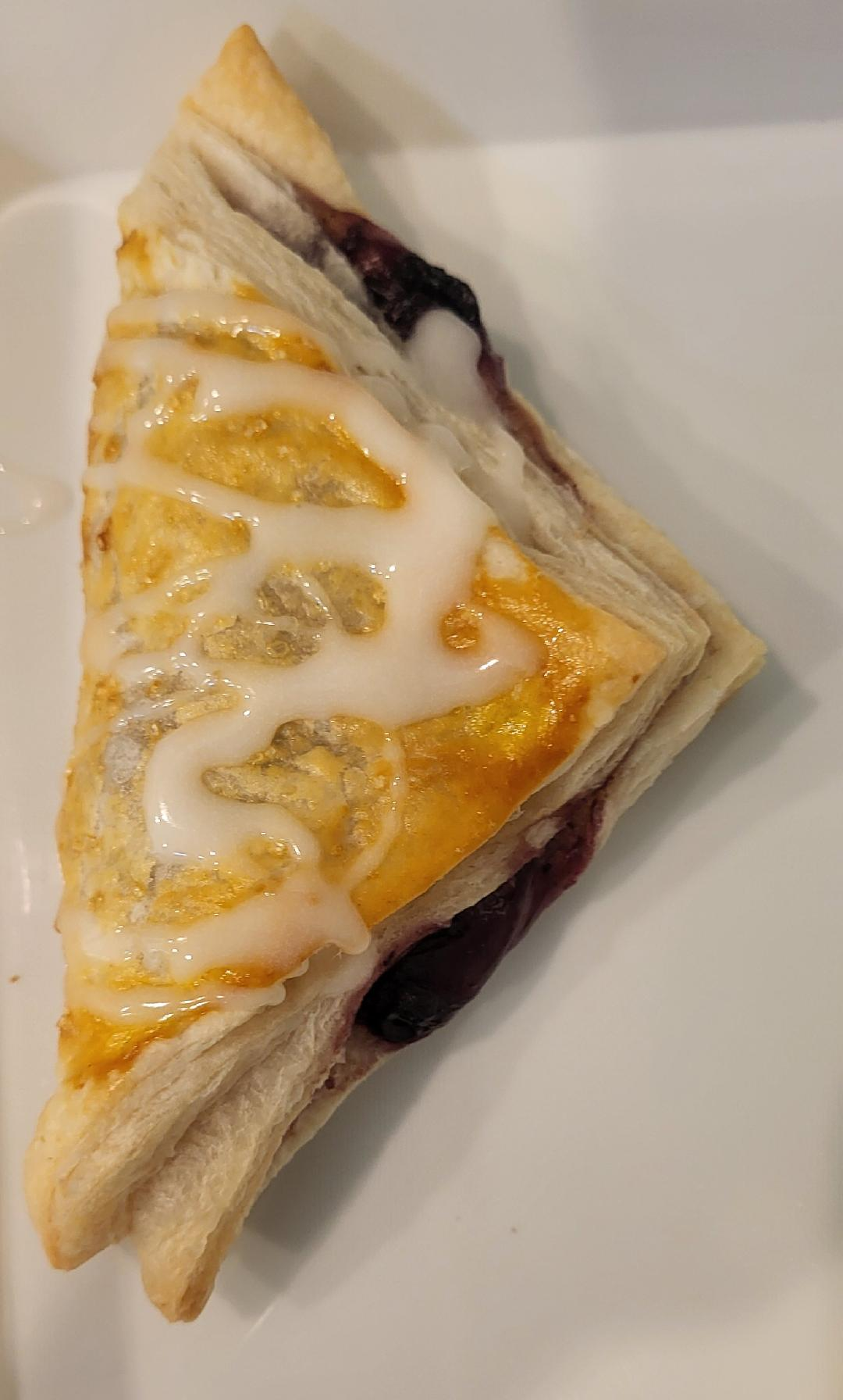Cupcakes with various colored frosting and toppings on a wooden board. A brownie is in front.