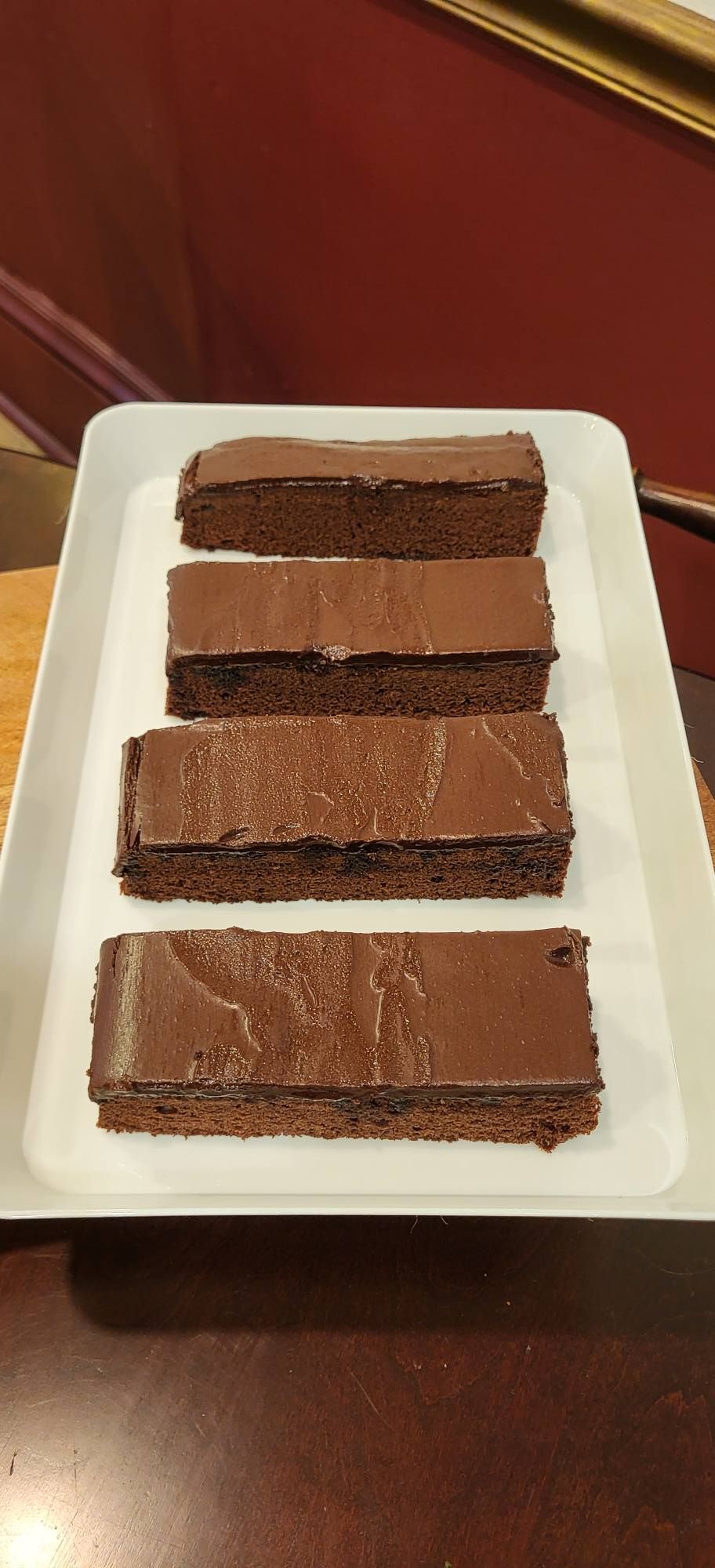 Several round pies on plates, some with various toppings, on a wooden surface near a window.