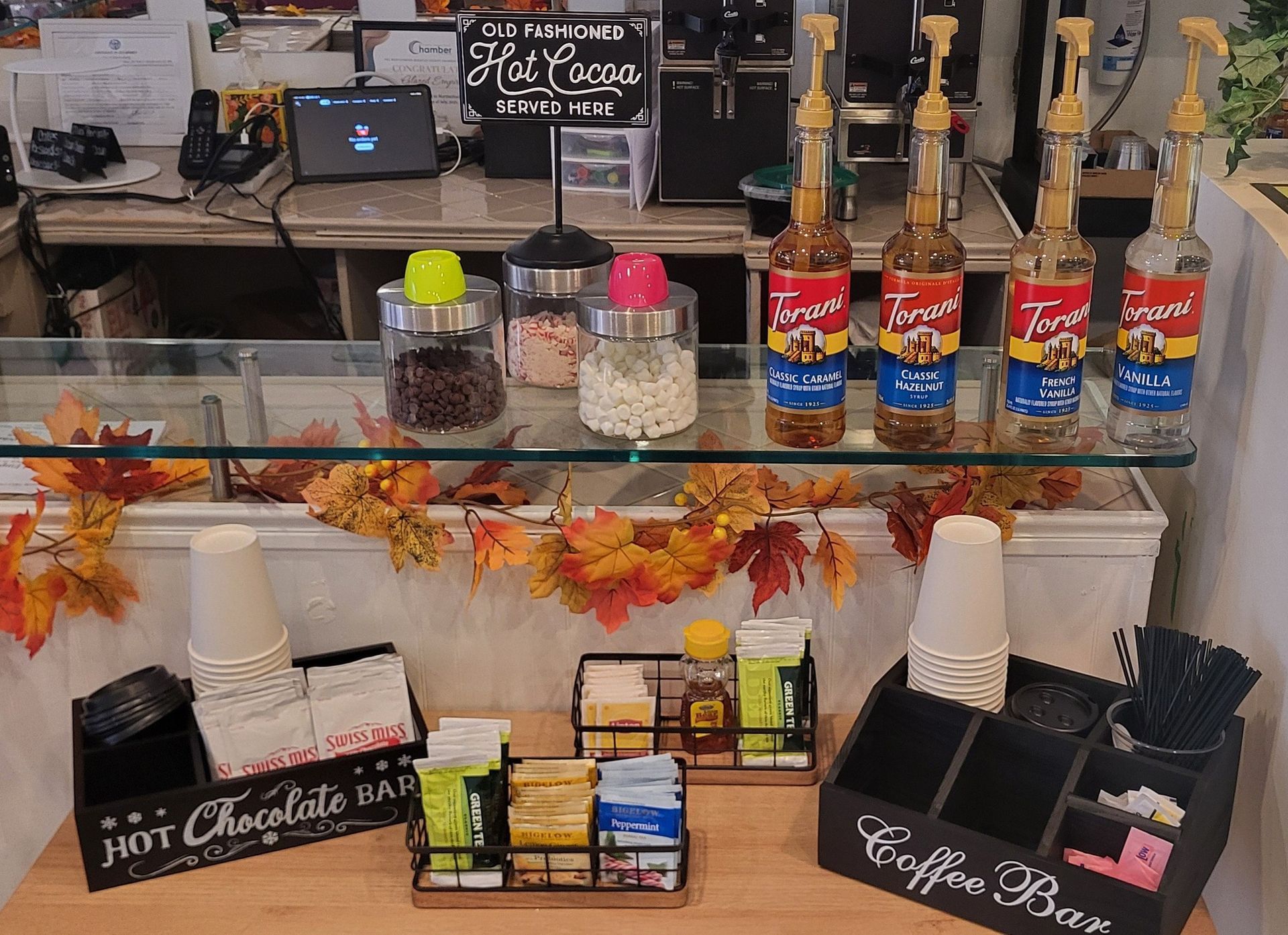 Cupcakes on a tiered stand, topped with bird wings. A pie is next to it.