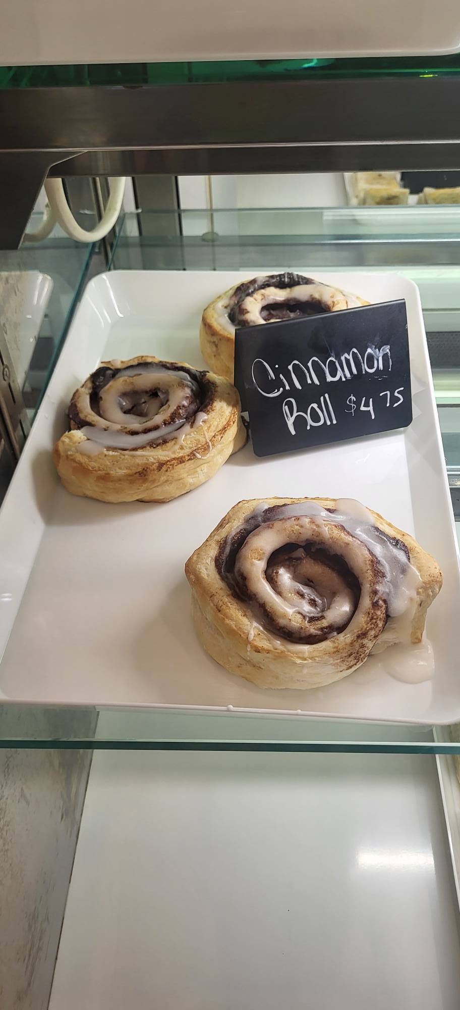 Slice of peach cobbler on a white plate, fork inserted. Peach filling and golden crust visible.