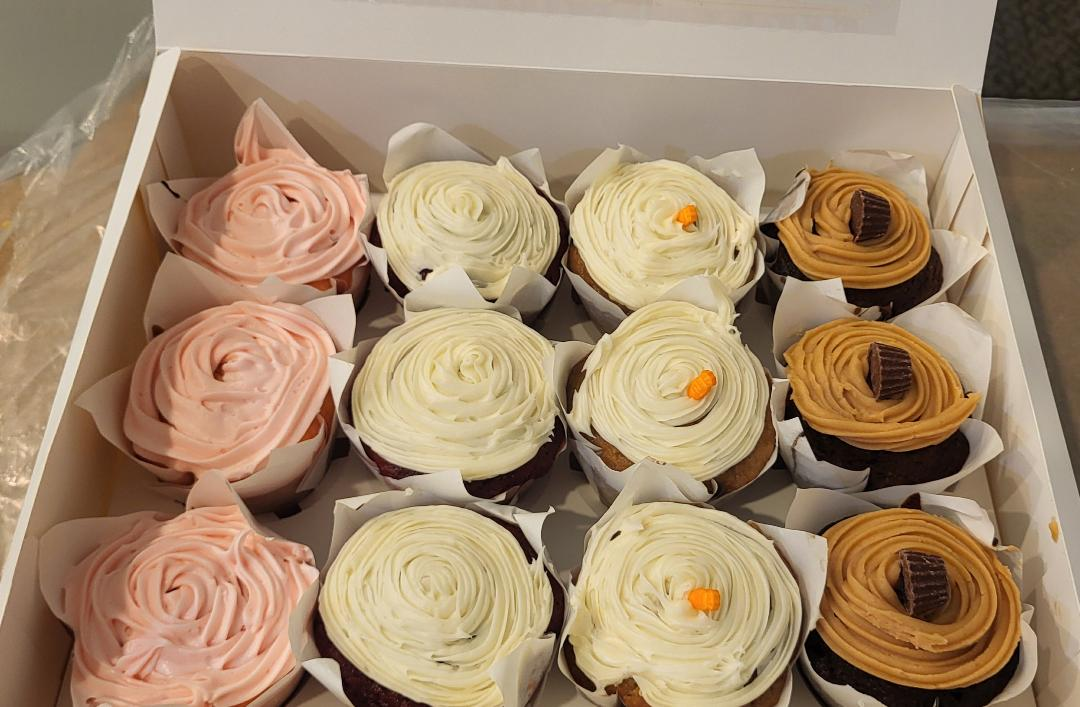 Heart-shaped Valentine's Day cake with white frosting, red hearts, strawberries, and
