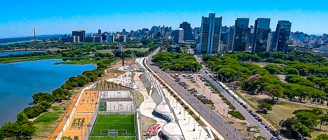 Uma vista aérea de uma cidade com um campo de futebol em primeiro plano.