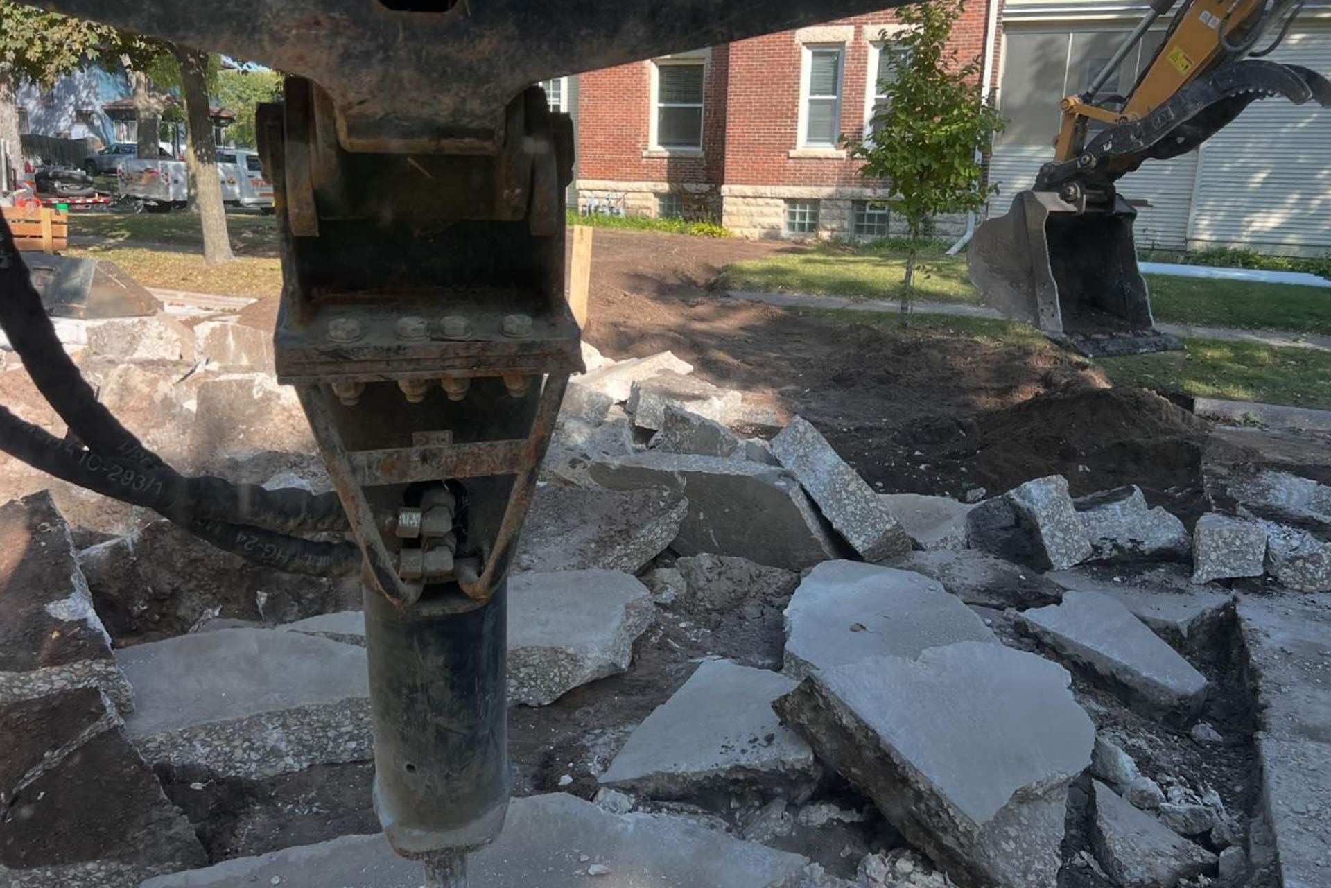 A bulldozer is breaking concrete in a yard