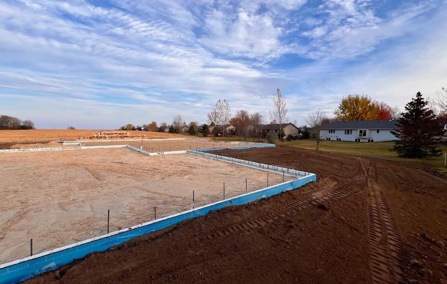 A house is being built in the middle of a dirt field.