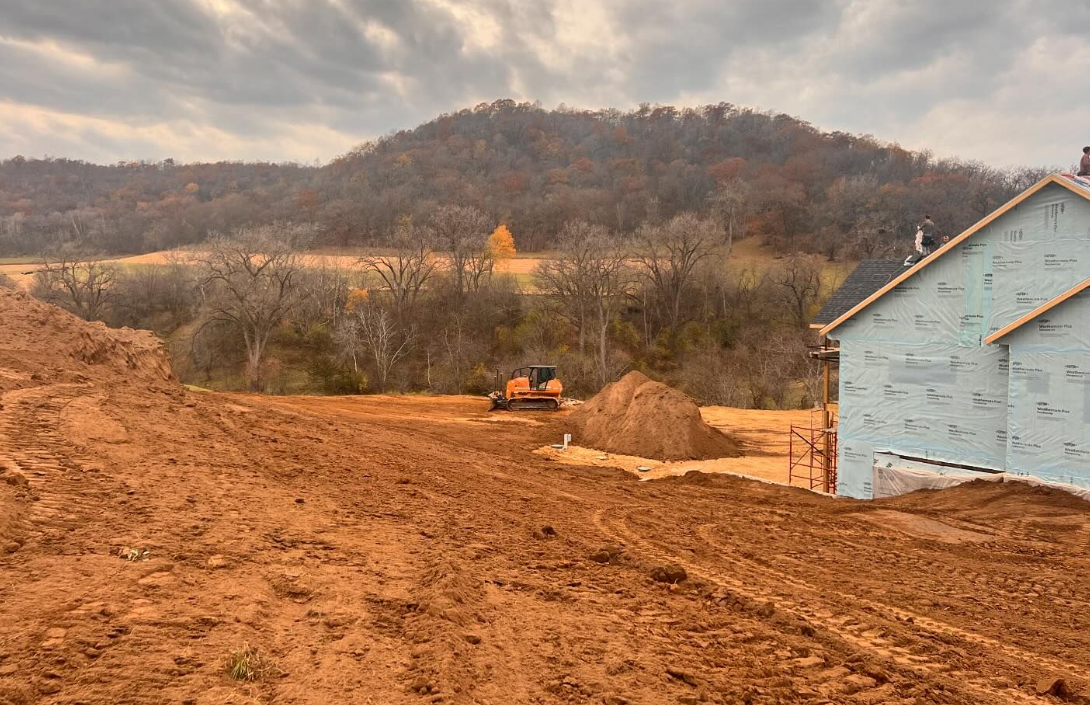 A house is being built in the middle of a dirt field.